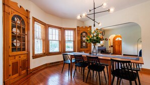 A dining area with a wooden table, chairs, and a chandelier. - 5BR w/ 6 King Beds + Hot Tub (Louisville)
