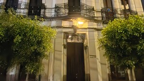 A historic building with ornate architecture, a prominent entrance, and a balcony with railings.