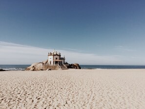 A beach with a small chapel-like structure on a rock, surrounded by sand and the ocean. - Flowerstreet54 - Fascinating LoveSeats at Porto downtown (Porto)