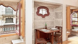 A dining area with a stone wall, a wooden table, and chairs.
