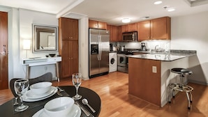 A modern kitchen with wooden cabinets, stainless steel appliances, and a central island with seating.