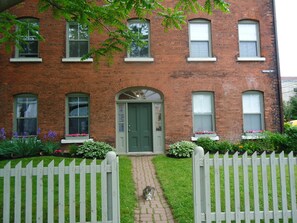 Charming two-story home with a cozy front porch and a small white picket fence.