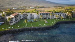 Ein Resort mit mehreren Gebäuden, einem Schwimmbad und einer felsigen Küstenlinie.