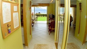 Ein Hotelzimmer mit Meerblick, ein Essbereich mit Außenbestuhlung und ein Bulletinboard mit verschiedenen Mitteilungen.