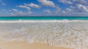 A beach with clear turquoise water and white sand.