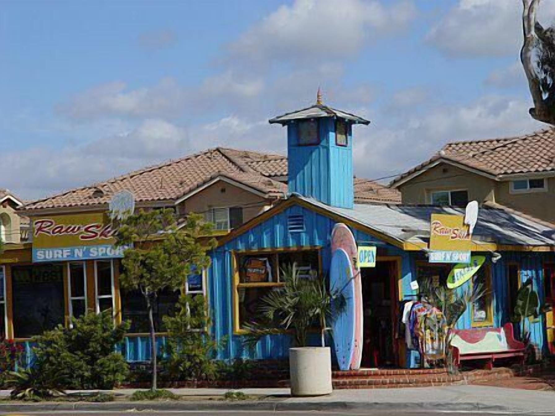 A building with a surfboard, a sign reading "Surf N' Sport", and a blue tower.