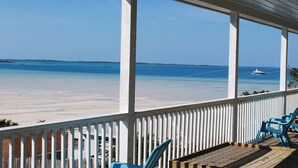 A covered outdoor area with a view of a beach and ocean.