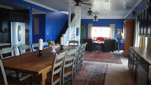 A spacious kitchen with a wooden dining table, chairs, and a refrigerator.