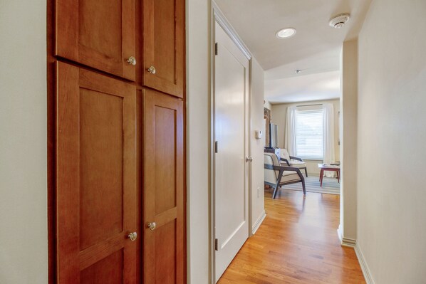 A hallway with wooden doors, a dining area with a table and chairs, and a window with blinds. - Sunny Midtown 2BD/BA Central Location! (Oklahoma City)