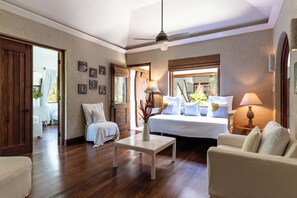 Une pièce comprenant un lit, un canapé, une table basse et un ventilateur de plafond.