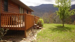 Eine Holzhütte mit einer Holzterrasse und einer kleinen Veranda.