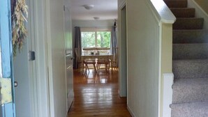 A hallway leading to a dining area with a view of the outdoors. - Highly Rated Cottage in Orleans, Cape Cod (Orleans)
