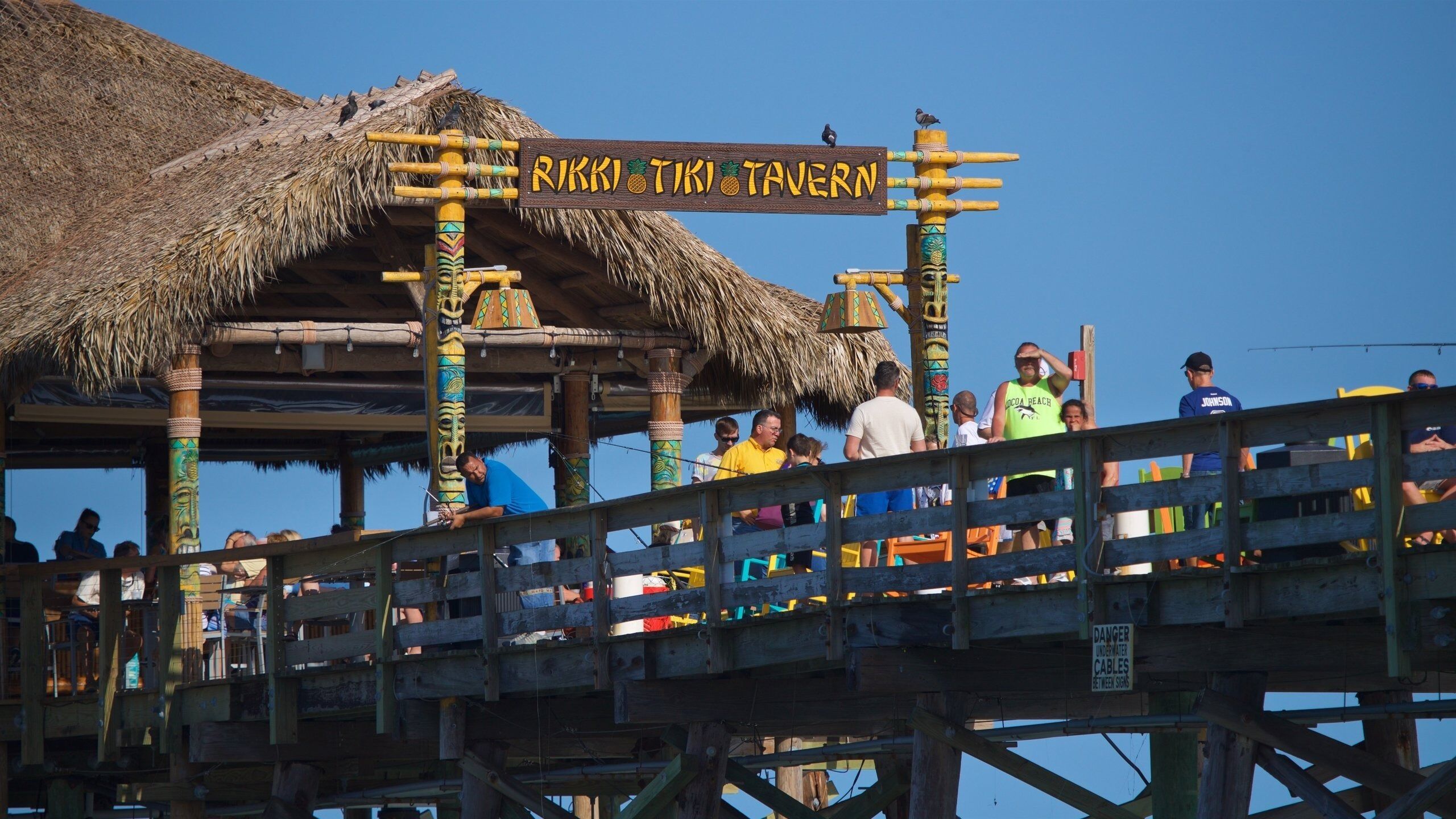 A tiki-themed restaurant with a thatched roof and colorful decorations.