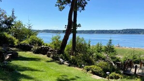 Une zone herbeuse offrant une vue sur un lac et des collines lointaines.