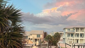 A waterfront property with a dock, lounge chairs, and a pool reflecting the sky. - Perdido Key Waterfront Home with boat dock, canal, Gulf right across the street (Pensacola)