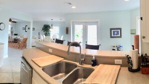 A modern kitchen with a stainless steel refrigerator, double sinks, and a coffee maker. - Perdido Key Waterfront Home with boat dock, canal, Gulf right across the street (Pensacola)