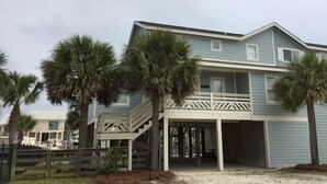 A two-story house with a balcony and a covered porch. - Perdido Key Waterfront Home with boat dock, canal, Gulf right across the street (Pensacola)