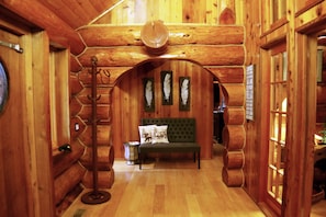 Cozy cabin interior with a central seating area featuring a bench and decorative pillow.