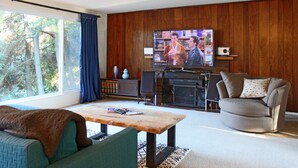 A living room with a television, a fireplace, a sofa, and a coffee table. - Cozy Kirkland Finn Hill Home (Kirkland)