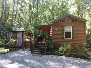 Eine Holzhütte mit Veranda und einer Treppe zum Eingang.