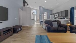 A modern living room with a flat-screen TV, dark leather sofa, and a wooden coffee table. - Recently renovated 5BR/4BA villa with private pool&spa located in Hampton Lakes. (Davenport)