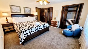 Un dormitorio con cama, mesita de noche, cómoda y una silla.