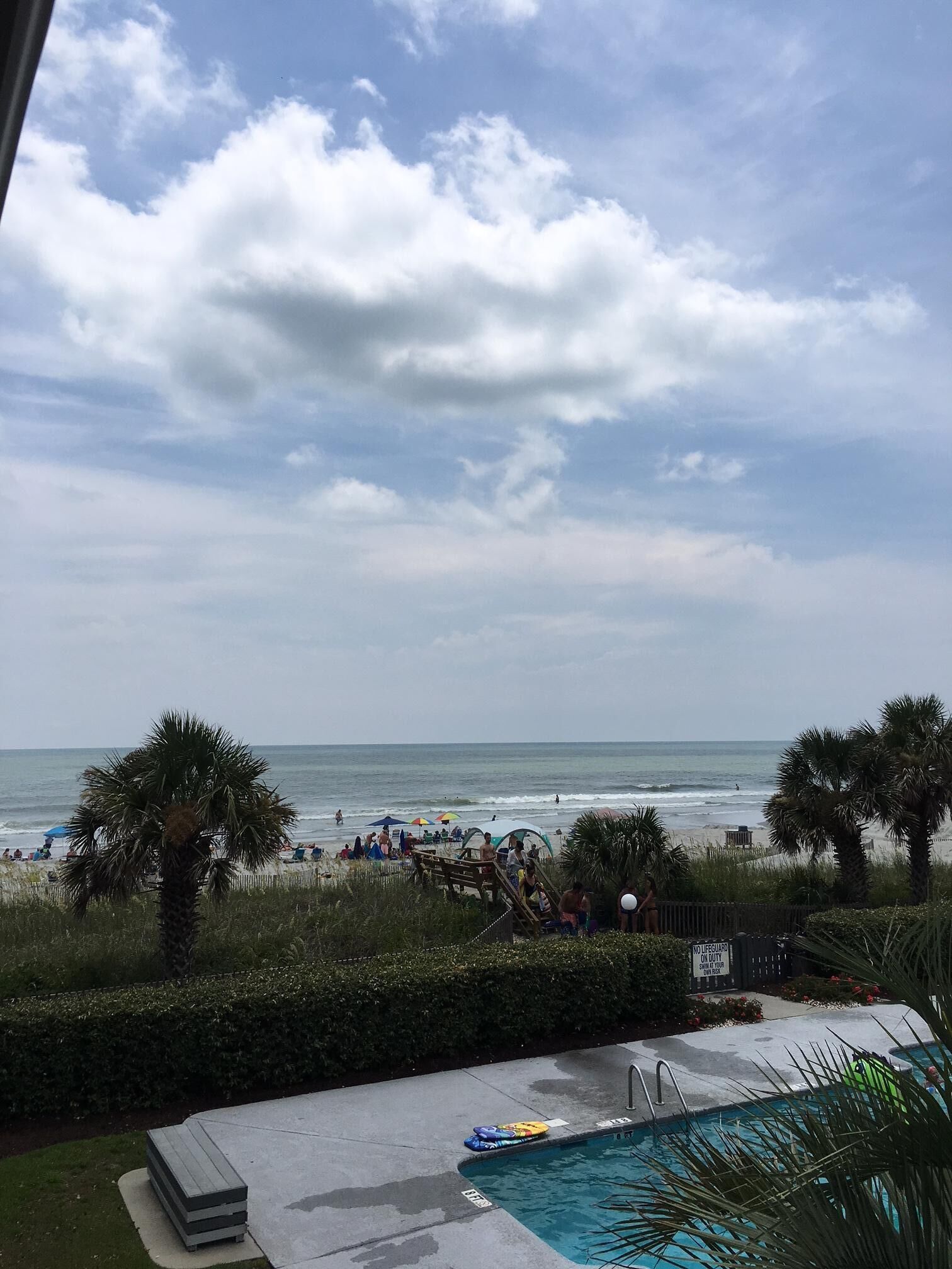 Ein Poolbereich mit Blick auf den Strand und den Ozean.