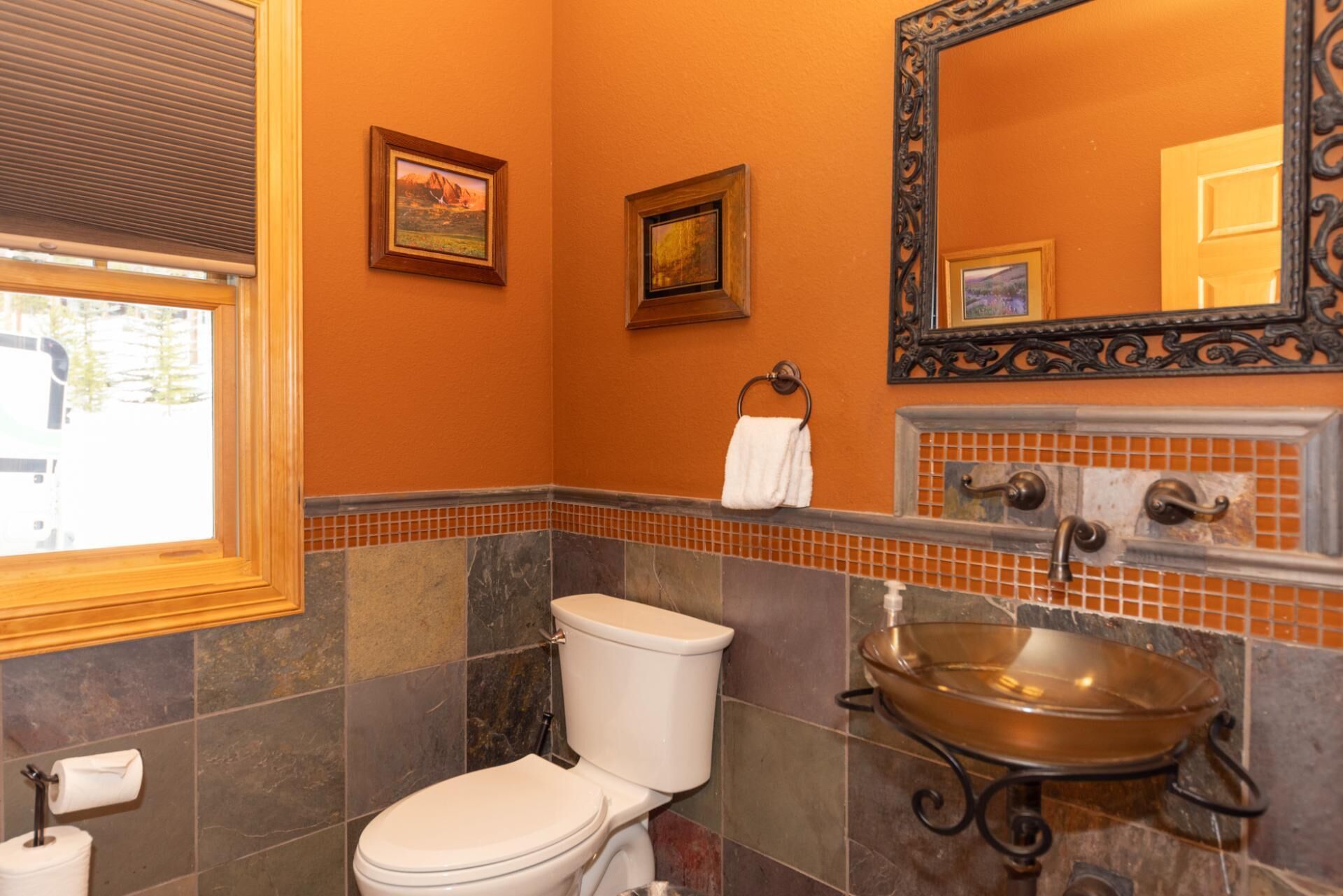 A bathroom with a toilet, a sink with a basin, and a mirror.