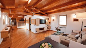 A spacious living area with wooden beams, a TV, and a sofa. - Charme Romantic Apartment Core Of Historic Center Of Modica (UNESCO) Sicily (Modica)