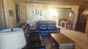 A cozy living room with a sectional sofa, a wooden coffee table, and a lamp. - Fishing, Hunting, Hiking, And Lots Of Family Fun!! Direct View of Escudilla Mtn (Nutrioso)