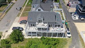 Une maison à deux étages avec une grande terrasse, un garage et une allée.