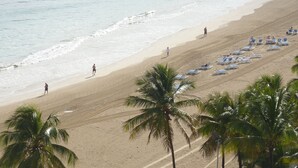 A beach with rows of sun loungers and palm trees. - Rooftop, private garden penthouse, 2 beach view Bedrooms, free parking, WIFI (Isla Verde, Carolina)