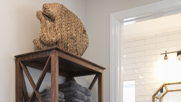 A wooden towel rack with folded towels, a white bathroom vanity, and a hexagonal mirror. - Upstairs so Sunny and Bright 2 Blocks to the Beach (Folly Beach)