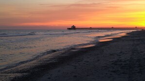 A beach with a pier extending into the ocean. - Upstairs so Sunny and Bright 2 Blocks to the Beach (Folly Beach)
