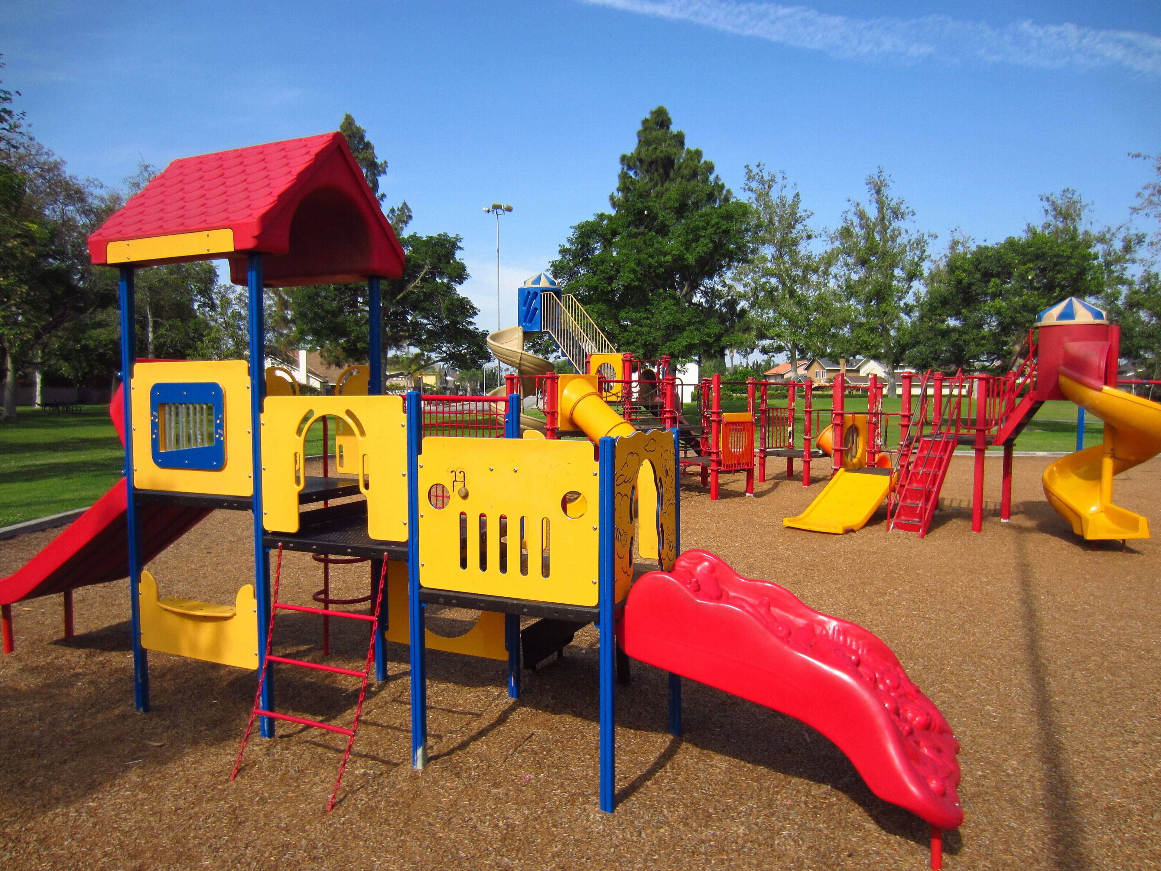 A playground with various play structures including slides and climbing areas.