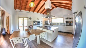 A spacious kitchen with wooden beams, a central island, and modern appliances. - VILLA VOLCANO- Rural peaceful Gem under the Volcano  (LAJARES)