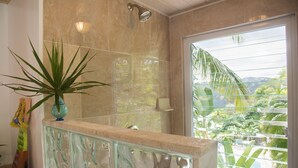 A bathroom with a shower, a potted plant, and a window with a view of greenery. - Fantastic Panoramic Views of The British Virgin Islands, Amazing Sunrises, Pool  (Coral Bay)