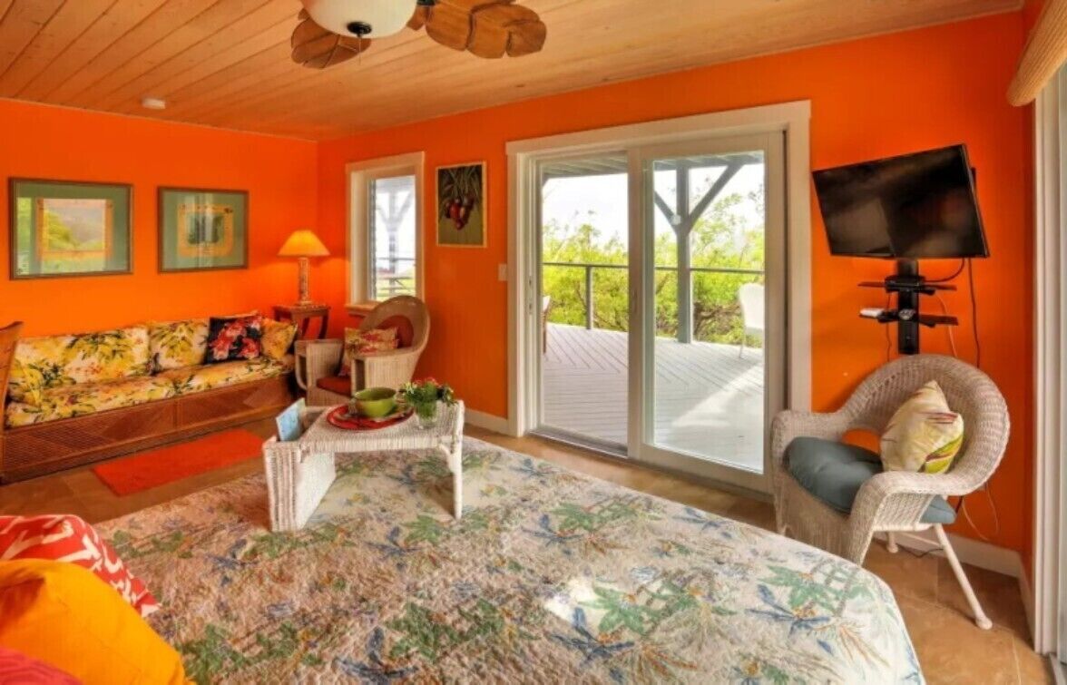 Quarto com sofá, cadeira, mesa e televisão.
