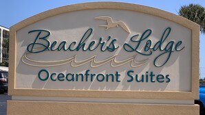 Une enseigne pour le Beacher's Lodge Oceanfront Suites, avec la silhouette d'un oiseau et des lignes ondulées.