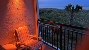 Un balcon avec vue sur la plage et l’océan.