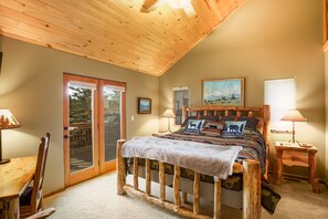 A bedroom with a wooden bed frame, a large window, and a door leading to a balcony.