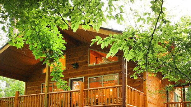 A wooden cabin with a balcony and a window.