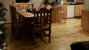 Una cocina acogedora con armarios de madera, una mesa de comedor con sillas y un árbol de Navidad.