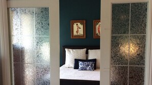 A bedroom with a bed, two pillows, and two framed pictures on the wall. - SALE! -- Best Location  &  Closest to the Beach - One Bedroom (kihei)