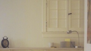 A kitchen with two stools, a window, and a wall-mounted clock. - Cozy English Basement Guesthouse (Washington)