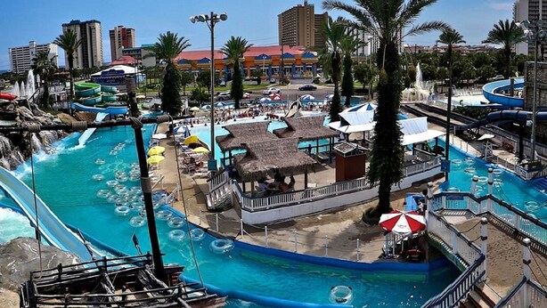 A water park with a large pool, slides, and a boat. - Upscale Home, Pool, Hot Tub, EV Charger, Pets OK, 10% Off Golf Cart Rentals (Miramar Beach)