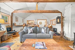 A cozy living room with a grey sofa, wooden coffee table, and a fireplace. - Beautiful & One-of-a-Kind Downtown Minturn - Minutes to Vail (Minturn)