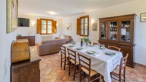 Un coin repas avec une table dressée pour quatre personnes, entourée de chaises en bois.