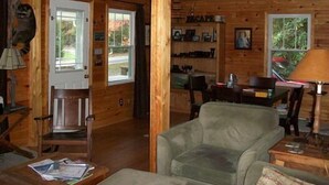 A cozy cabin interior with a wooden interior, a dining area, and a living room with a sofa and chairs. - Mammaw's Lakefront Cabin bordering The Blue Ridge Parkway (Jefferson)