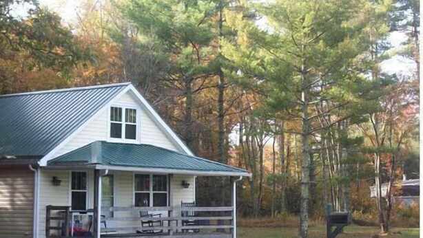 A white house with a green roof, a porch with benches, and a mailbox. - Mammaw's Lakefront Cabin bordering The Blue Ridge Parkway (Jefferson)